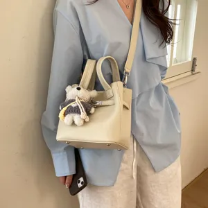 Chic leather tote bag with shoulder strap and cute bear pendant, stylish daily crossbody bag.