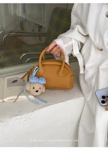 Korean minimalist Boston handbag for women, chic shell bag with cute plush dog pendant.