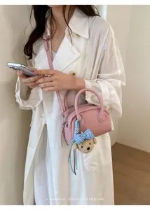 Pink boston shoulder bag for women, minimalist chic crossbody bag with cute bear pendant.