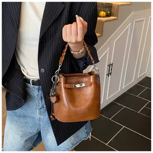 Retro brown leather bucket bag with metal lock closure and chic braided top handle style.