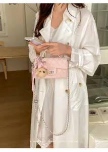Pink quilted chain crossbody bag with cute bear pendant, elegant vintage style for women.