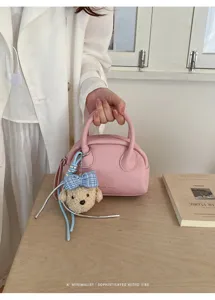 Pink boston handbag with cute bear charm and blue plaid bow, elegant minimalist retro style detail shot.