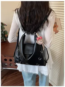 Vista dettagliata dello zaino borsa in pelle nera, elegante con dettagli di anelli metallici.