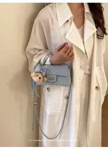 Dettaglio in primo piano della borsa trapuntata da donna con chiusura elegante e ciondolo.