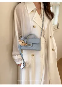 Borsa a tracolla trapuntata azzurro chiaro con catena, manico e ciondolo orsetto carino elegante.