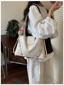 Primo piano della borsa a tracolla minimalista che mostra la sua finitura strutturata e i cinturini.