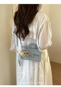 Borsa a mano trapuntata elegante con ciondolo a orsetto chic e chiusura a girello.