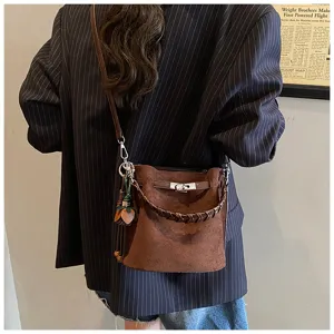 Vintage brown suede bucket bag for women, chic shoulder and crossbody bag with braided handle.