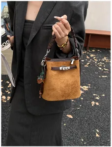 Retro brown suede bucket bag with metal lock closure and braided handle, stylish handbag.