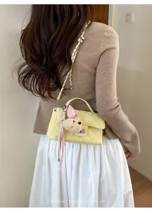 Elegante borsa a tracolla trapuntata gialla con catena, ciondolo cane di peluche e nastro rosa.
