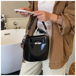 Retro black leather bucket handbag, chic braided top handle with metallic turn-lock closure.