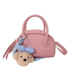 Pink leather Boston bag main view featuring top handles, shoulder strap, and cute bear plush charm.