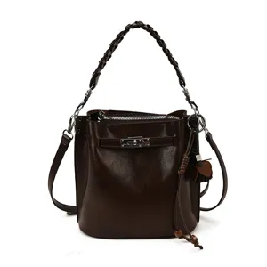 Vintage brown leather bucket bag with braided handle and chic metal lock for women.