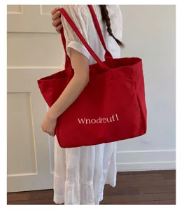Red canvas tote bag detail, casual large capacity shoulder bag with unique printed text.