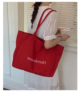 Red canvas tote bag detail view, casual large capacity shoulder bag with white letter print.