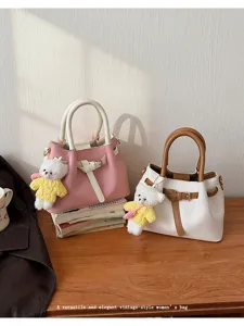 Details of stylish contrast color women bucket bag with cute bear pendant and top handle.