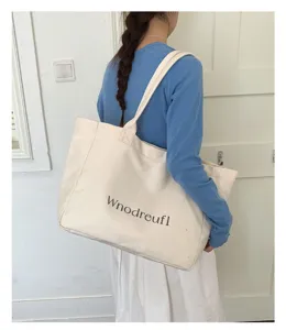 Casual large canvas tote bag detail view, worn by model for daily commuting style.