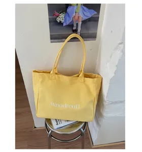 Detailed view of yellow canvas tote bag, spacious single shoulder design for daily use.