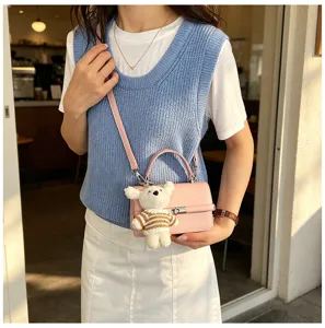 Stylish pink shoulder bag for women, cute small square crossbody bag with knit bear charm.