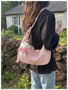 Chic pink hobo shoulder bag for women, stylish dumpling crossbody bag with cute bear pendant.