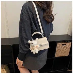 Chic textured women shoulder crossbody bag with cute bear pendant for spring fashion style.