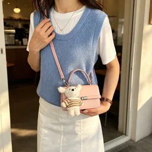 Chic pink top handle shoulder bag for women, trendy casual crossbody bag with cute bear charm.