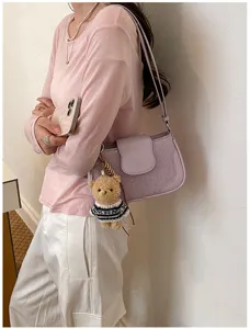 Women stylish purple underarm shoulder bag with cute bear pendant for daily spring outfits.