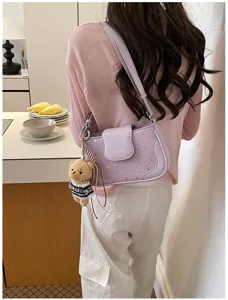 Detail view of a stylish purple underarm shoulder bag with star details and cute bear charm.