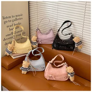 Close-up of stylish shoulder bags with star prints, cute teddy charms, and elegant bows.