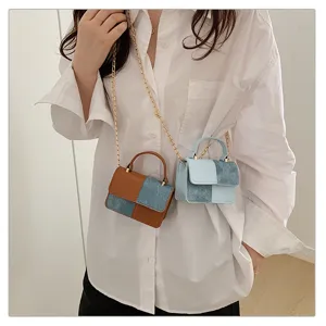 Detail view of fashionable mini chain crossbody bag worn by model in casual wear.