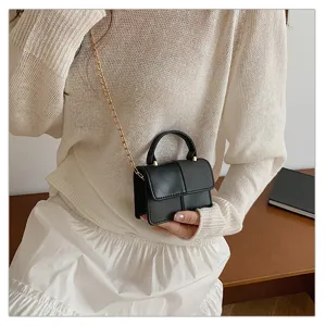 Black mini crossbody shoulder handbag with top handle and gold chain for women daily use.