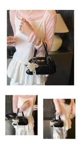 Korean style black patent leather bowling handbag with pearl bow pendant for women daily commute.