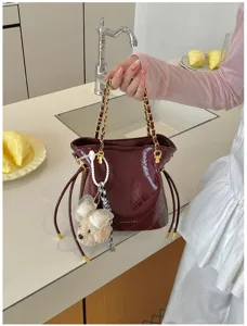 Elegant quilted bucket bag with chain strap and cute bear charm for casual daily commuting style.