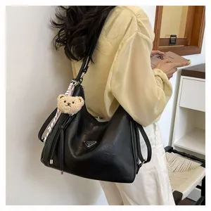 Detailansicht der großen schwarzen Damen Schultertasche aus Leder mit Bärenanhänger.