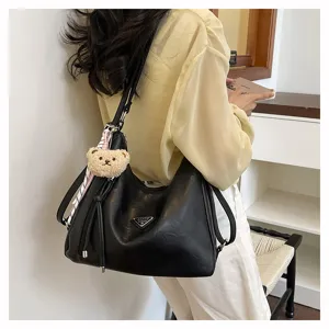 Detailansicht der schwarzen PU-Leder-Damen-Hobo-Umhängetasche mit süßem Plüschbären-Anhänger.