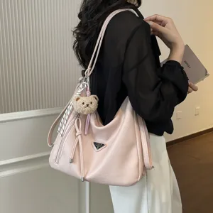 Rosa slouchy Damen Schultertasche, große Tote Tasche mit Bären Anhänger und Metalllogo.
