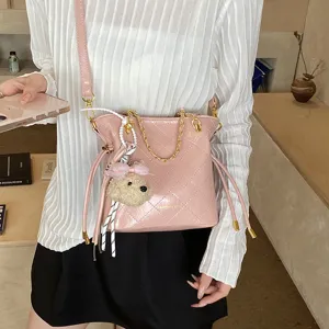 Pink quilted shoulder bag with gold chain strap and cute puppy pendant for daily use.