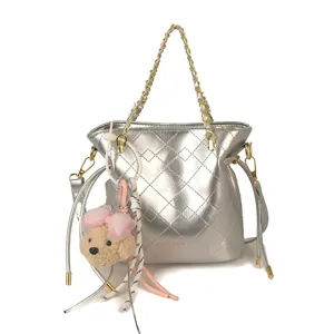 Silver quilted bucket shoulder bag with gold chain strap and cute bear pendant for women.