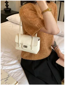 Detail van witte kunstlederen schoudertas met litchipatroon, elegante minimalistische tas.