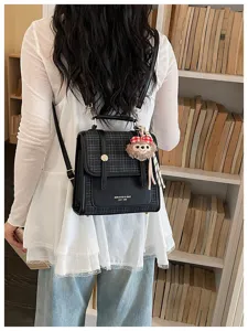 Korean style contrast backpack for women retro commuter shoulder bag with cute plush pendant.