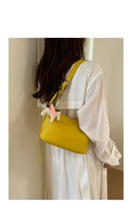 Minimalist yellow leather shoulder bag for women, stylish underarm bag with cute pegasus charm.