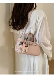 Pink leather shoulder bag with cute horse charm, vintage style chic minimalist crossbody bag.