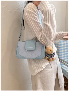 Women stylish light blue shoulder bag with star pattern and cute bear plush pendant for summer.