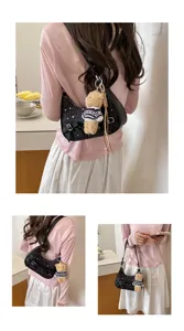 Detail view of women's black star pattern hobo shoulder bag with cute plush bear pendant.