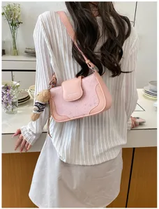 Fashion pink leather underarm shoulder bag for women with cute bear pendant and star decor.
