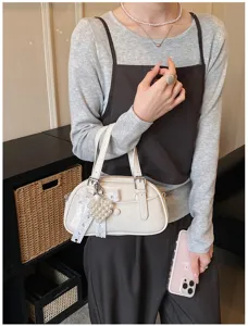 Close-up detail of the stylish white bowling handbag featuring a cute pearl heart pendant.