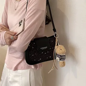 Stylish black star pattern shoulder bag with cute bear pendant for women daily casual wear fashion.
