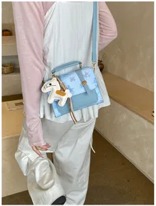 Chic light blue crossbody handbag with cute horse charm, trendy fashion women shoulder bag.