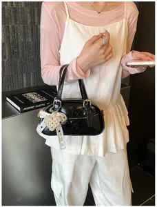 Black patent leather bowling handbag with pearl lace pendant for women daily chic commute.