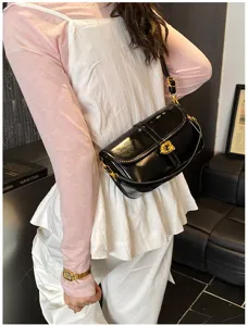 Élégant sac porté épaule en cuir verni noir pour femme, sac axillaire chic et minimaliste.